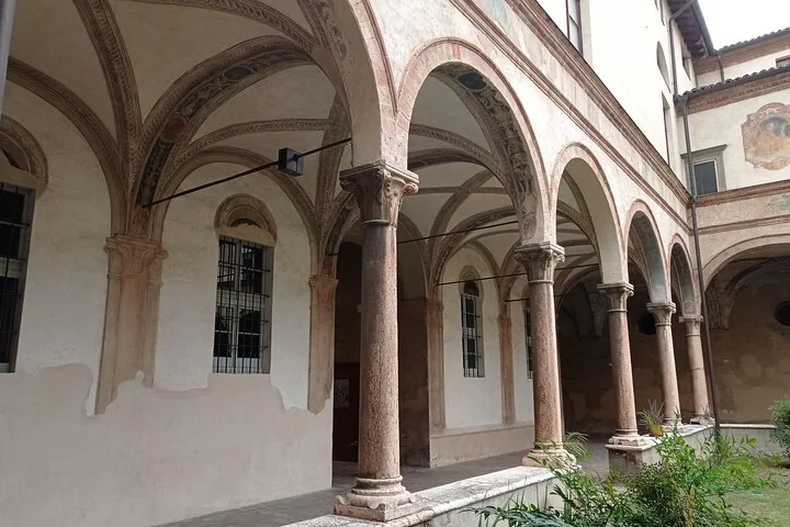 A Renaissance cloister with slender marble columns, round arches and frescoed vaults
